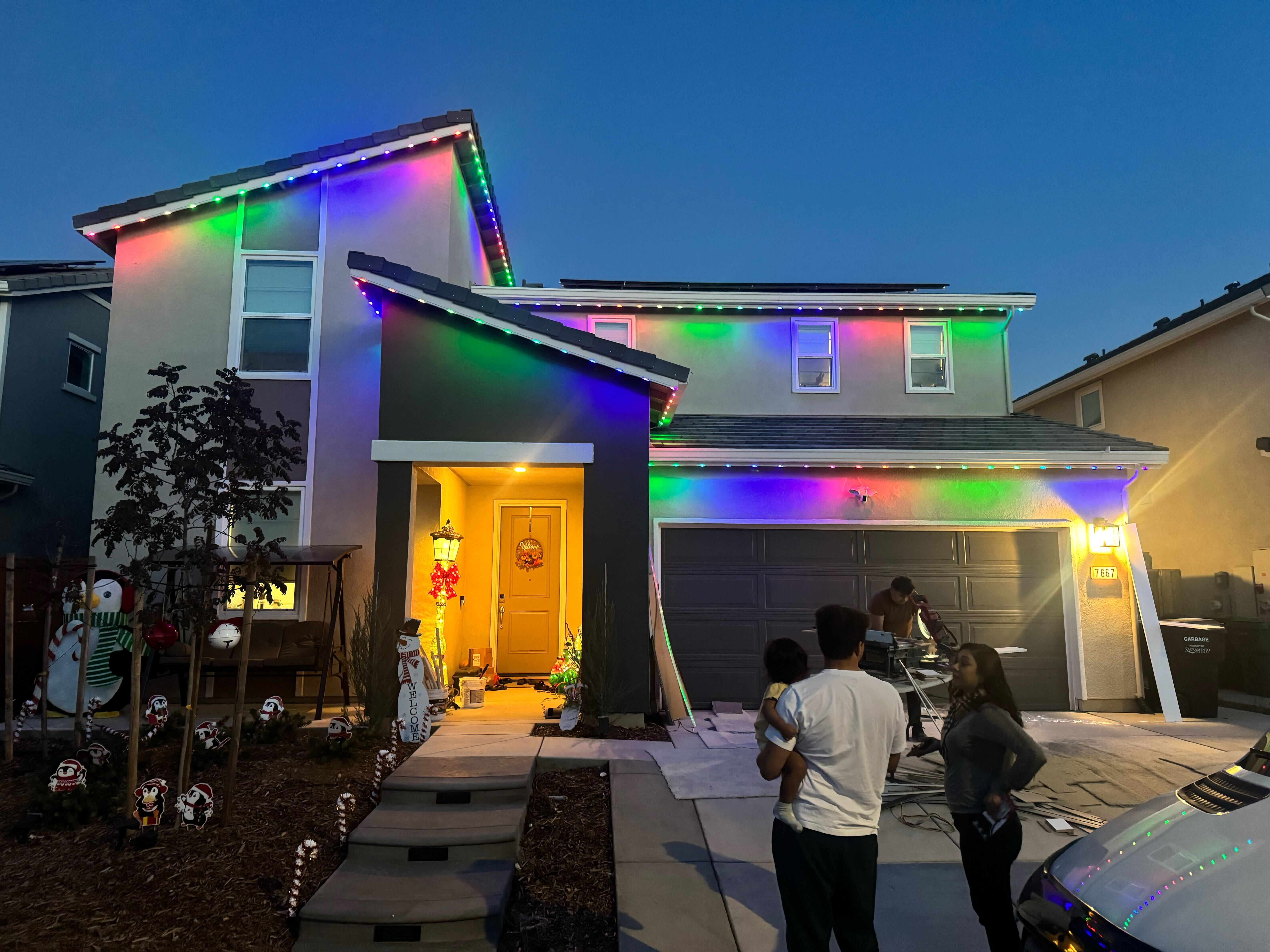 Family looking at their newly installed permanent lighting in their home